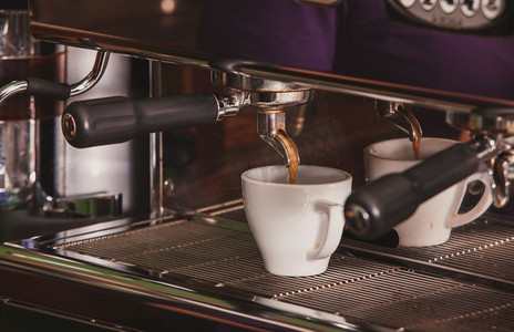 研磨咖啡摄影照片_特写咖啡师研磨咖啡，调味浓缩咖啡。浓缩咖啡的制作工艺