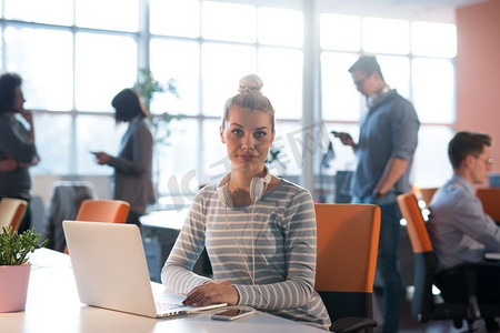 年轻女企业家自由职业者在合作空间使用笔记本电脑工作