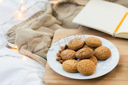 食品、面包店和hygge概念-在木板的燕麦饼干在家。燕麦饼干与杏仁板在家里