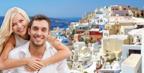 旅游、旅游和暑假概念-快乐的情侣拥抱圣托里尼岛背景。幸福的情侣在圣托里尼岛上拥抱
