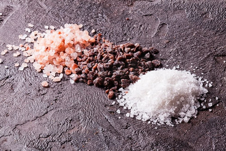 矿物山脉摄影照片_各种盐类，粉色喜马拉雅山脉和黑色与海盐的板岩背景。各种类型的盐类