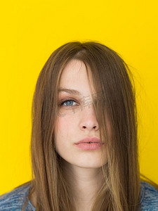 一位美丽积极的年轻女子玩耍着黄色背景下孤立的丝质长发