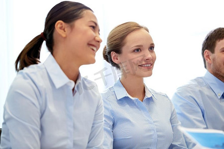 商业、人和团队合作的概念-微笑的女商人在办公室会面。一群微笑的商界人士在办公室会面