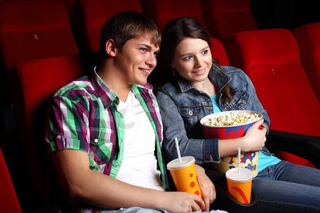 看电影摄影照片_年轻夫妇坐在电影院里看电影
