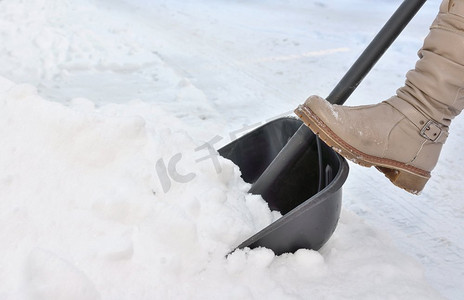 冬天，一名妇女在街上铲雪