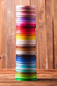 各种颜色的丝带筒子像一座塔一样矗立着。桌上的丝带线轴