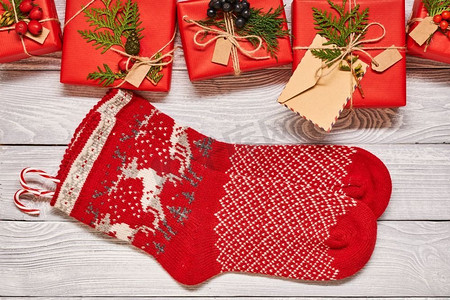 创意包装和装饰圣诞礼物的盒子和长袜在白色的木制背景。从上面俯瞰。复制空间。