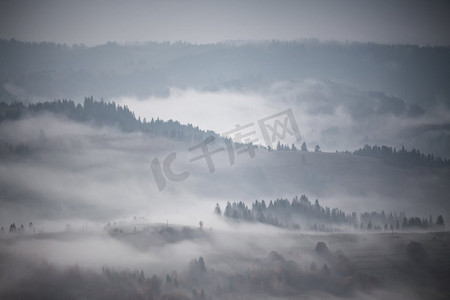 秋天的山雨和雾气。晨雾笼罩着山丘和森林。山顶周围有浓雾。秋季背景