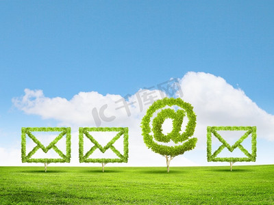 绿色植物图标摄影照片_电子邮件概念。电子邮件标志形状的绿色植物的概念形象