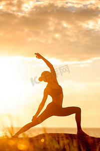 练习瑜伽的高加索健身女性。日落时分练习瑜伽的高加索健身女性