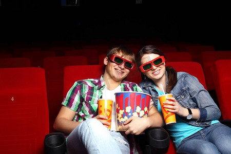 坐在车里看电影摄影照片_年轻夫妇坐在电影院里看电影
