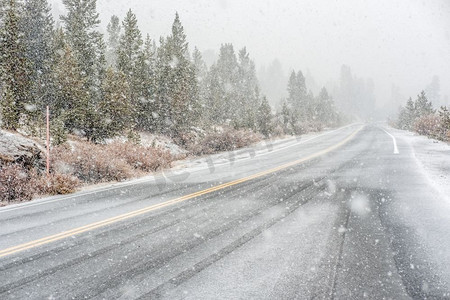 暴风雪从约塞米蒂国家公园开始，蒂奥加山口。潮湿的积雪道路。美国加利福尼亚州。