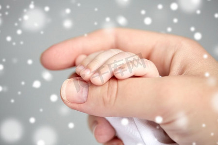 家庭、母性、人和儿童保育理念--特写母婴交接雪花。母亲和新生儿手的特写镜头