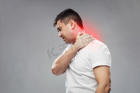 人，医疗保健和问题概念-不快乐的男人患有灰色背景下的颈部疼痛。患有颈部疼痛的不快乐男子