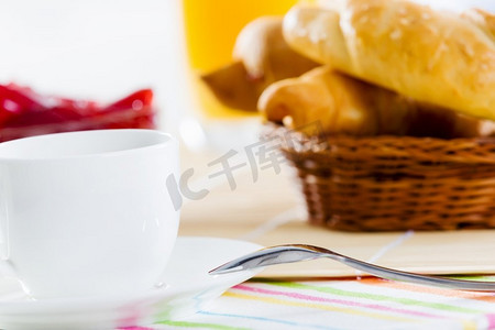 咖啡果冻摄影照片_美味的早餐。早餐桌上有牛角面包果冻和一杯咖啡