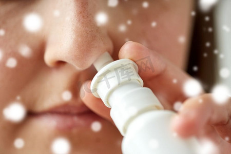 医疗保健、流感、鼻炎、医学和人的概念-病人在雪地上使用喷鼻剂的特写。使用鼻腔喷雾的女性病人的特写