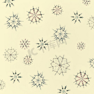 雪花图案摄影照片_圣诞节或冬天的概念。各种手工制作的雪花图案，由珠子和号角制成，米色背景，俯视
