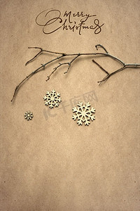 创意圣诞概念照片，棕色背景上有雪花的树枝。