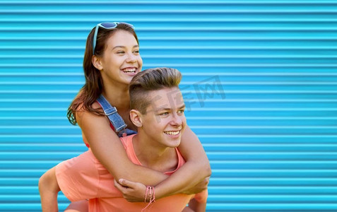 夏天，爱和人的概念-快乐的青少年夫妇在蓝肋骨背景下开心地笑着。快乐的青春期情侣在蓝色上玩耍