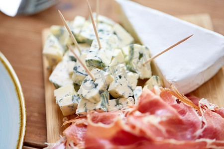 食物、餐饮和饮食概念--在木板上放蓝奶酪和果酱或帕尔玛火腿。蓝芝士和果酱或帕尔玛火腿配上木板