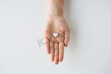 药物、营养补充剂与人的观念--心形手持丸的特写。手握药心丸特写
