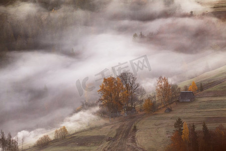 秋天的早晨，山村云雾缭绕，烟雾缭绕。在山上的山丘上耕种。森林里的一阵阵薄雾。