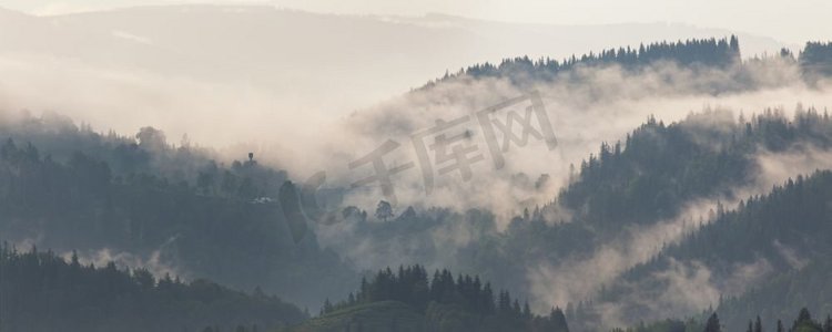 雨后不久的山景。云雾缭绕。山口上雾蒙蒙的村庄。雨后的山林景观