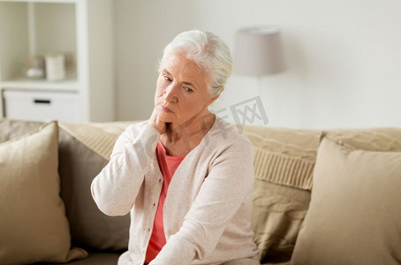颈部疼痛摄影照片_老年、健康问题与人的观念--老年女性在家中遭受颈部疼痛之苦。在家中遭受颈部疼痛的老年妇女
