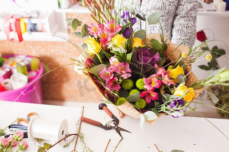 星历摄影照片_花商用五颜六色的花朵制作时尚的花束。花商制作花束