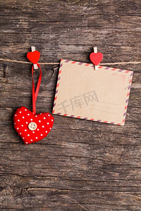 红色的心形和纸牌被红色的别针挂在绳子上，质朴的背景。情人节的概念&S