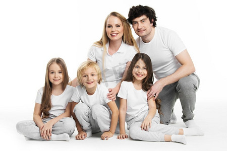 有孩子的家庭肖像。画室里一家人穿着白衣服，三个孩子隔绝在白色背景上