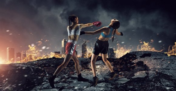 女孩们在户外打拳击。两个年轻漂亮的女人拳击对夜城市背景