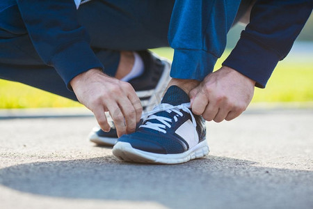一名男子在开始锻炼前系好鞋带。训练前调整运动鞋