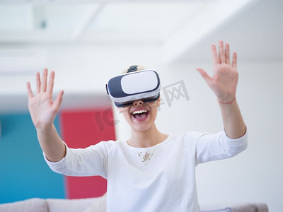 微笑快乐的女人获得经验使用VR耳机眼镜的虚拟现实在家里