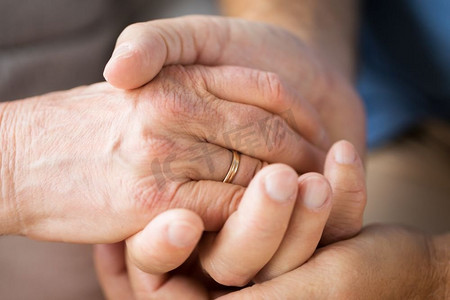 关系、婚姻和老人观念--老年夫妇牵手的特写。年长夫妇手牵手的特写