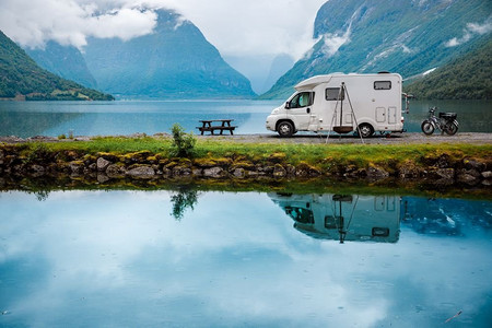 野营车摄影照片_家庭度假旅行房车，度假旅行在汽车之家，大篷车度假。挪威自然风光秀丽。