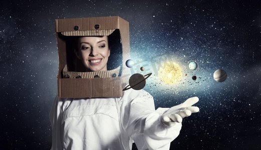 梦想探索太空。头顶纸箱的年轻女子想象自己是宇航员