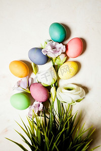 梅节日摄影照片_粉色梅布背景上的鲜花和鸡蛋，复制复活节问候的空间。鲜花和鸡蛋