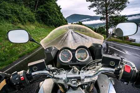 人在雨中摄影照片_骑摩托的人在雨中骑摩托车。第一人称视角。
