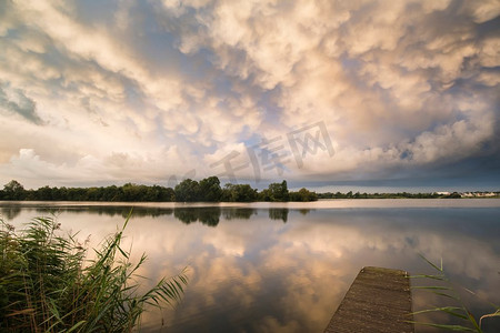 猛烈风暴前夕，令人惊叹的乳母云在湖泊景观上形成