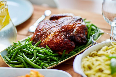 食物、烹饪和饮食概念--餐桌上点缀着青豌豆的烤鸡。餐桌上点缀着青豌豆的烤鸡