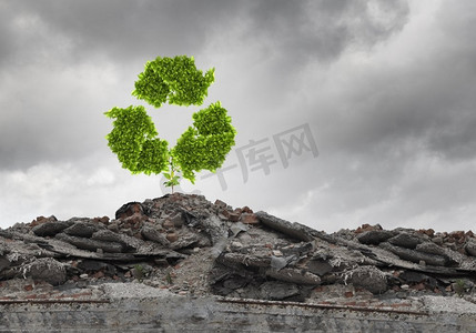 循环利用的概念。废墟上生长着循环绿色标志的概念形象