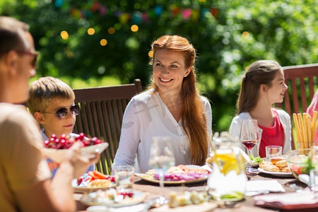 休闲、度假和人的概念-幸福的家庭有节日晚餐或夏季游园会。快乐的家庭共进晚餐或夏日游园会