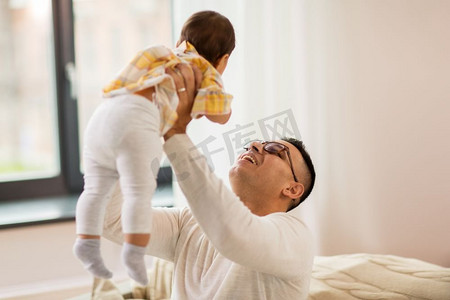 家庭、父亲和人的概念-幸福的父亲在家里抱着小宝宝。快乐的父亲在家里抱着小宝宝