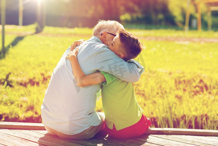 家庭、世代、沟通和人的概念-幸福的祖父和孙子在泊位上拥抱。祖父和孙子在卧铺上拥抱