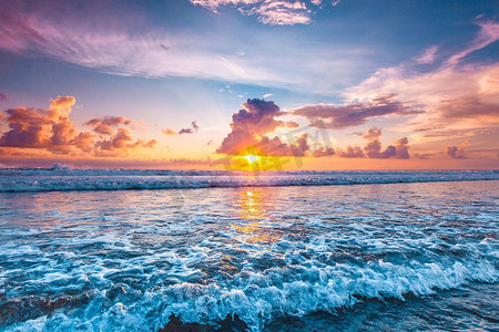 水波浪摄影照片_大海上的日落。美丽的落日天空背景前溅起的海浪