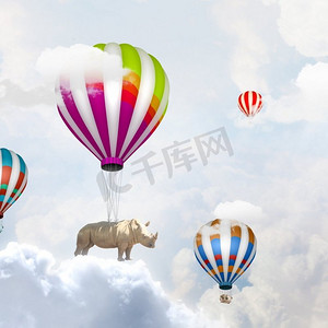 会飞的犀牛。犀牛坐在五颜六色的浮空器上高空飞翔