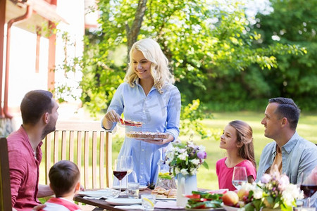 休闲、度假和人的概念-幸福的家庭有节日晚餐或夏季游园会。快乐的家庭共进晚餐或夏日游园会