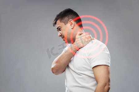 颈部疼痛摄影照片_人，医疗保健和问题概念-不快乐的男人患有灰色背景下的颈部疼痛。患有颈部疼痛的不快乐男子