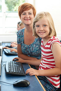 女小学生与老师在计算机课上的写真